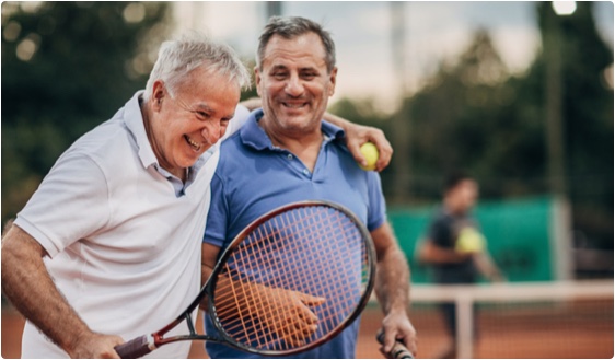 Stock photo of two older men playing tennis.